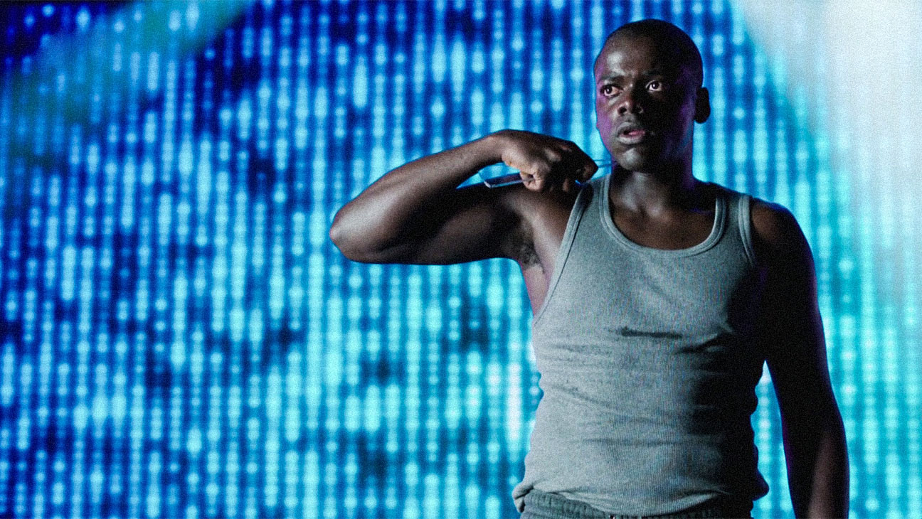 Daniel Kaluuya as Bing in 'Black Mirror' stands dramatically on a talent show stage, holding a shard of glass against his neck.